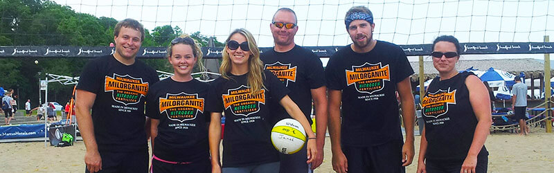 Individuals playing volleyball in Milorganite tshirts
