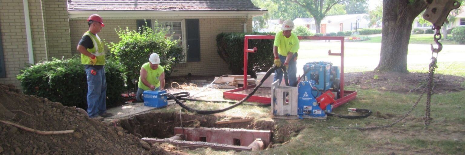 men repairing a home lateral on a sidewalk