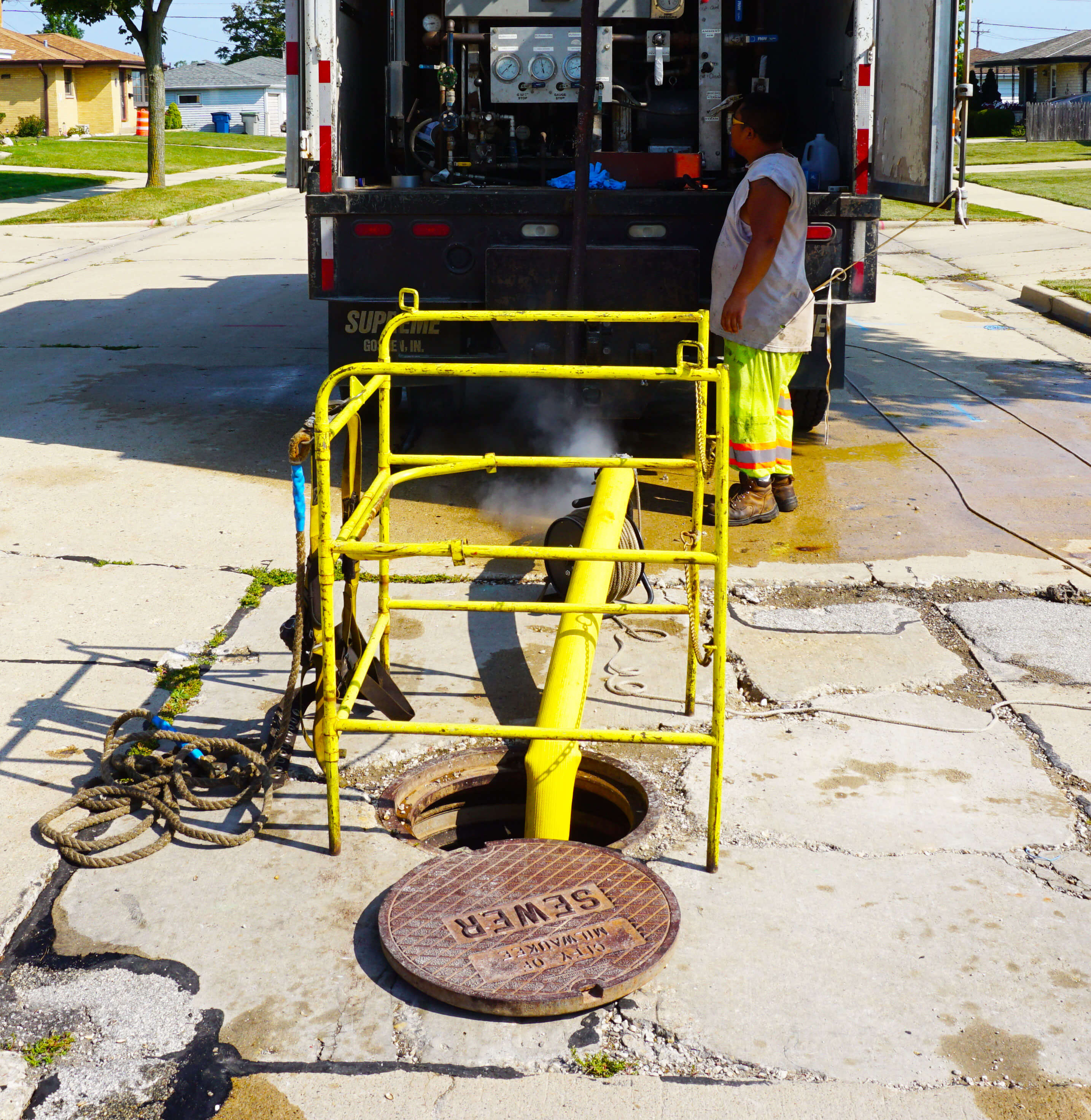 yellow hose in a street sewer hole