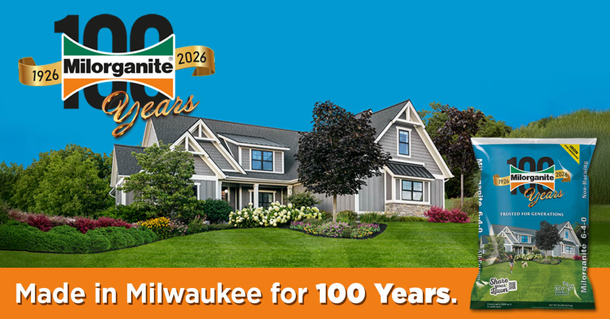 Milorganite Fertilizer 100th Anniversary bag and logo in a yard with a house