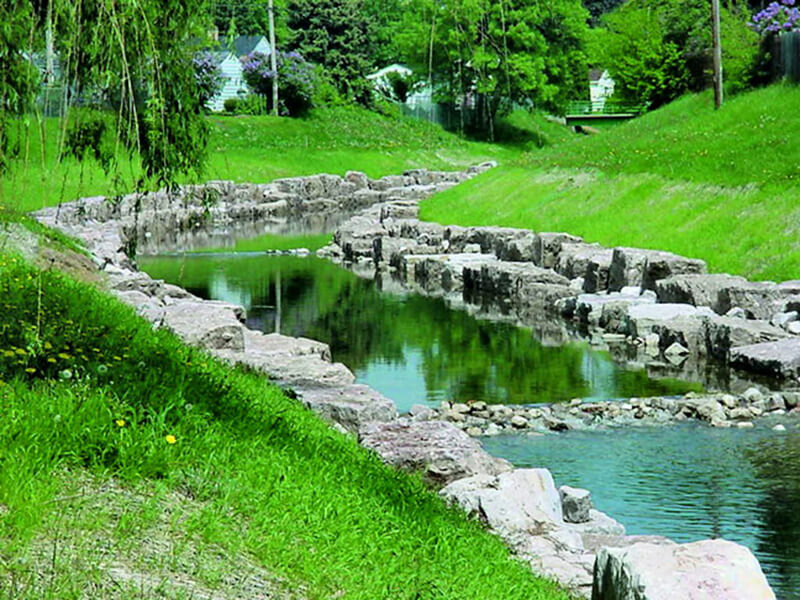 creek surrounded by rocks and grass