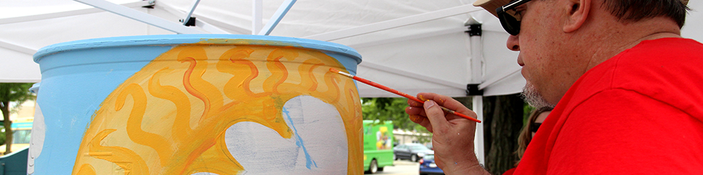 Man painting rain barrel