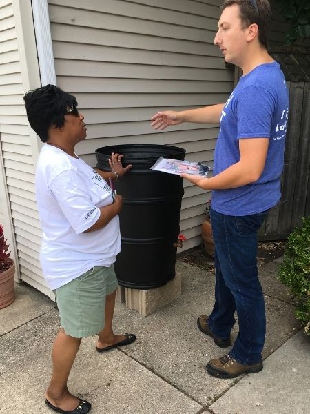 man explaining benefits of rain barrel