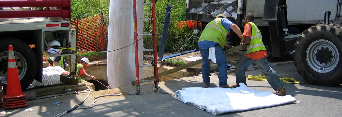 men lining underground pipe in street