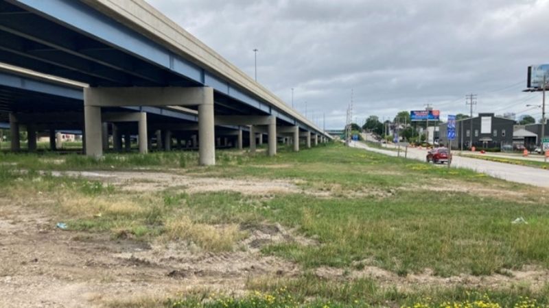 cement and grass underneath a highway overpass 