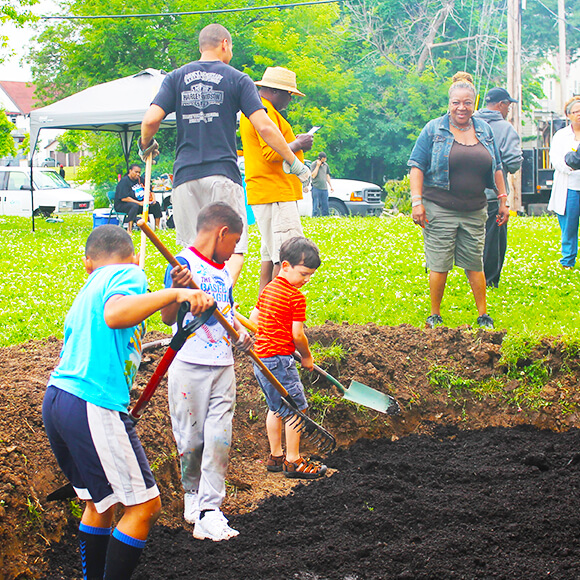 kids using shovels and rakes to help with the dirt